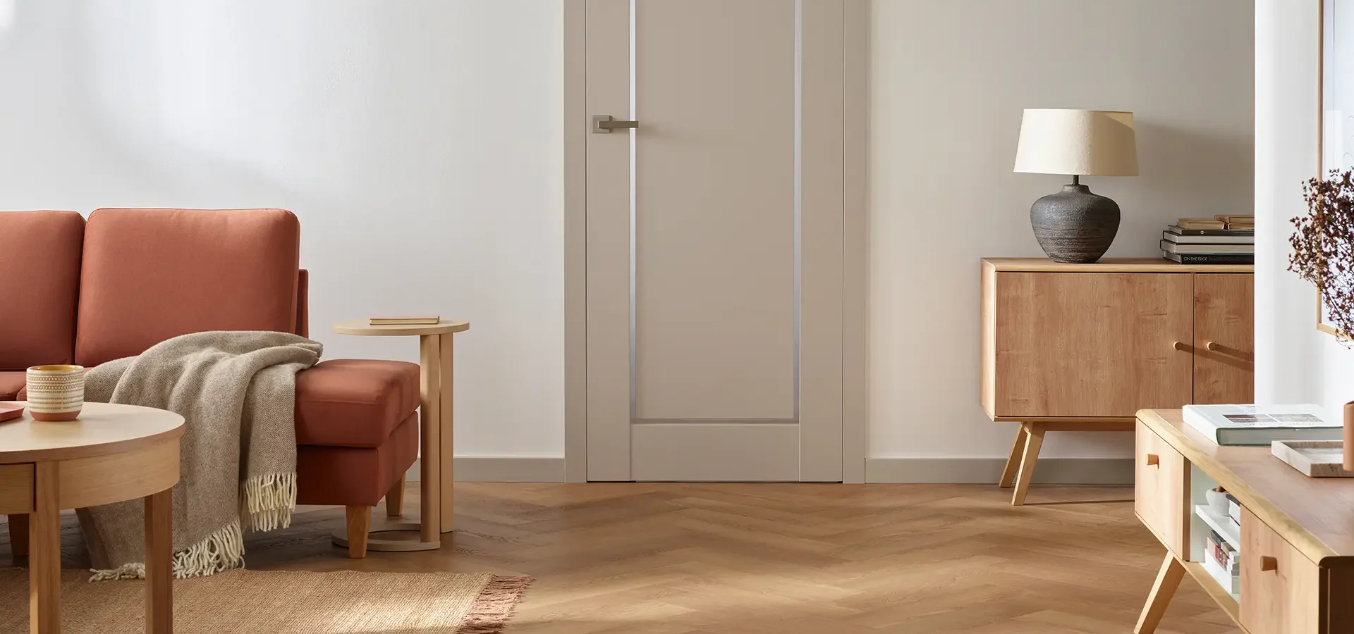 Laminowane drzwi z dekoracyjną ramką, komponujące się z aranżacją w stylu scandi.
